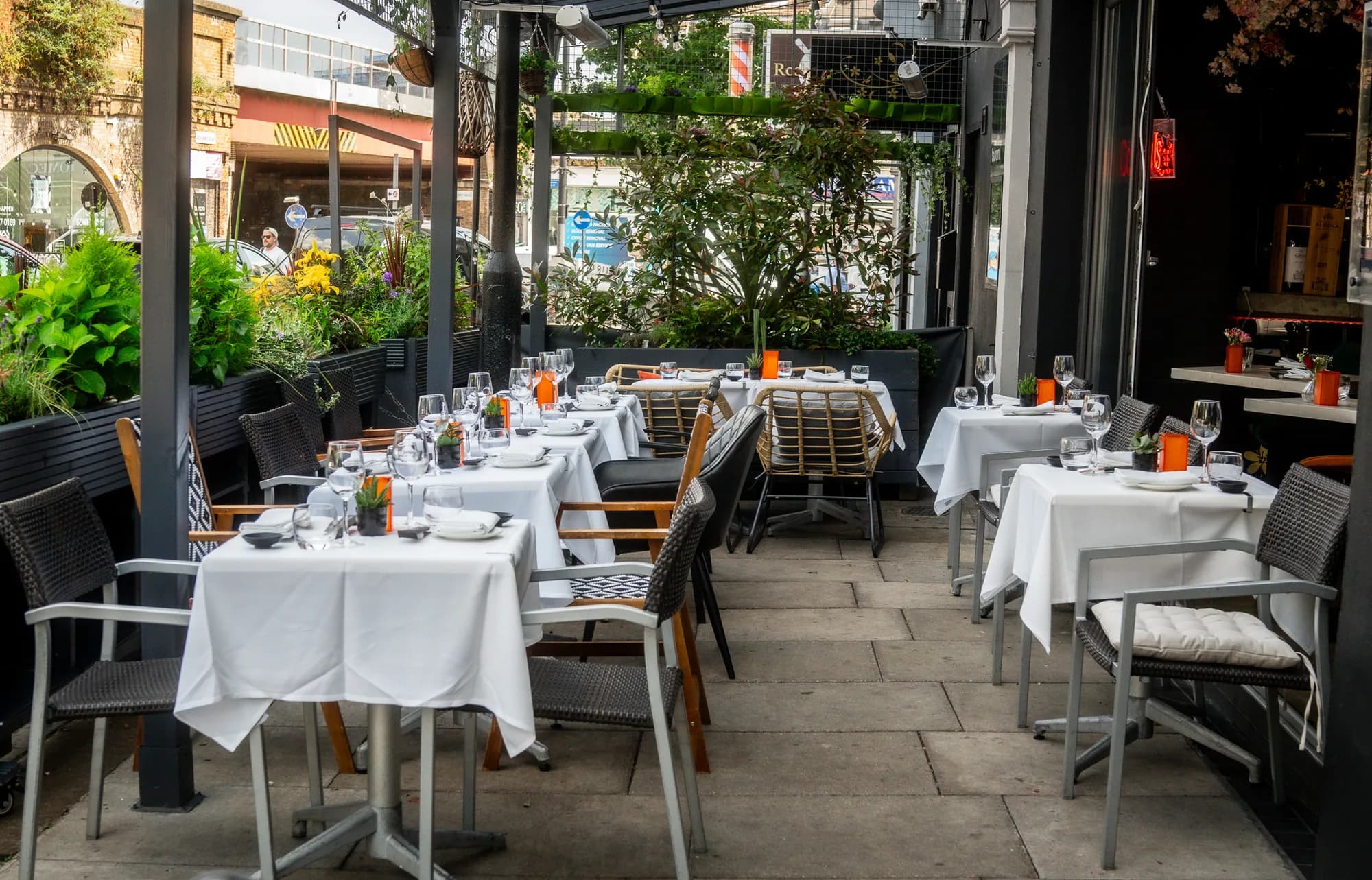 The Tsunami Clapham terrace on Voltaire Road, white linen tables under planters
